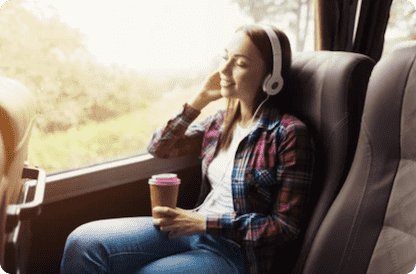 Фото дівчини, яка усміхається і слухає музику в автобусі